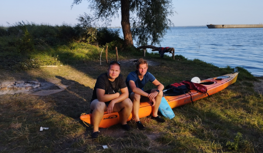 Dwóch chłopców siedzących na kajakach